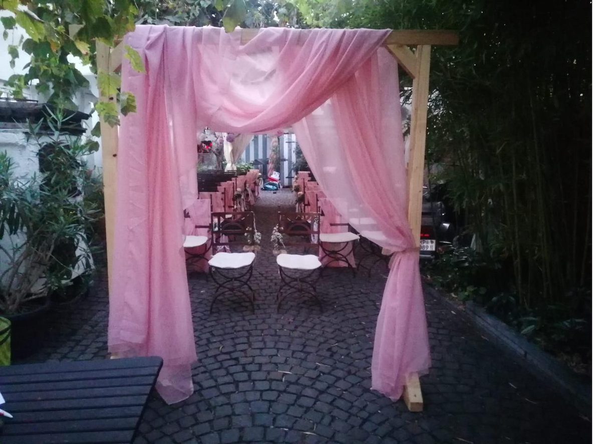 Hochzeitsbogen mit rosa Vorhangstoff im Innenhof des Ratskellers